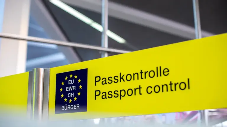 Dzeltena robežkontroles zīme lidostā ar uzrakstu Passkontrole un Passport control.