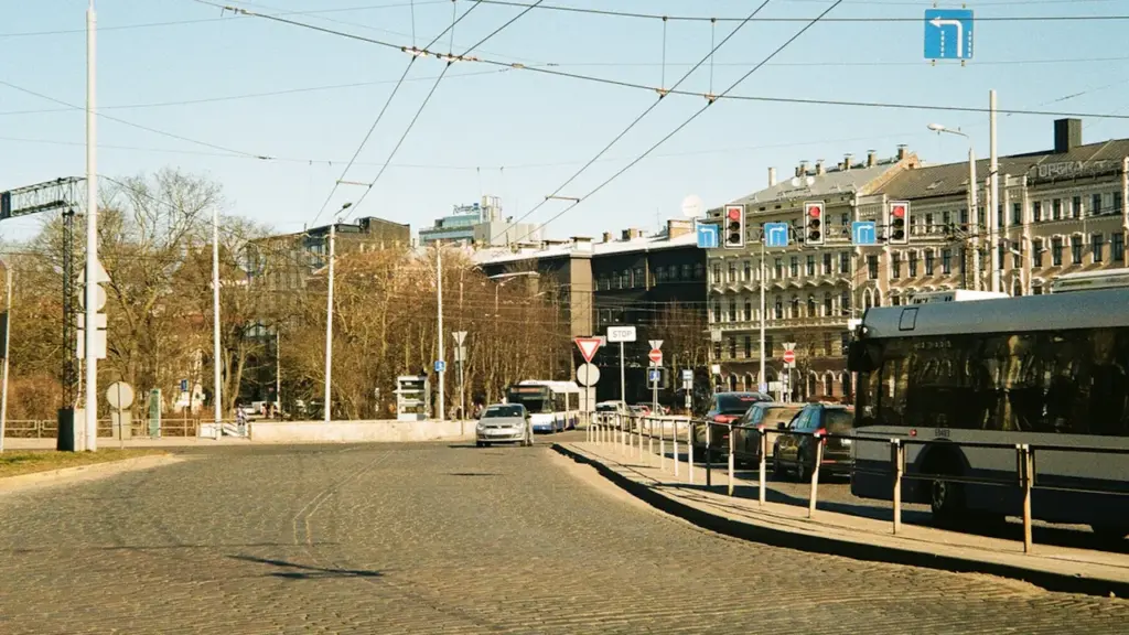 Pilsētas iela Rīgā ar sabiedrisko transportu un automašīnām dienas laikā.